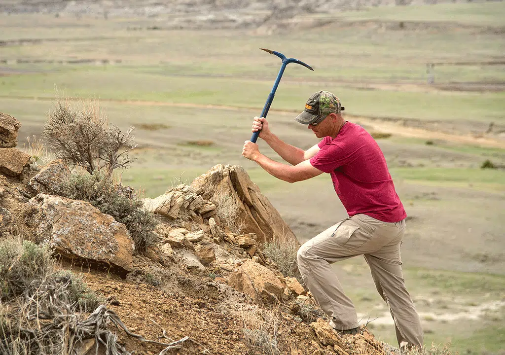 Man using pick on hillside