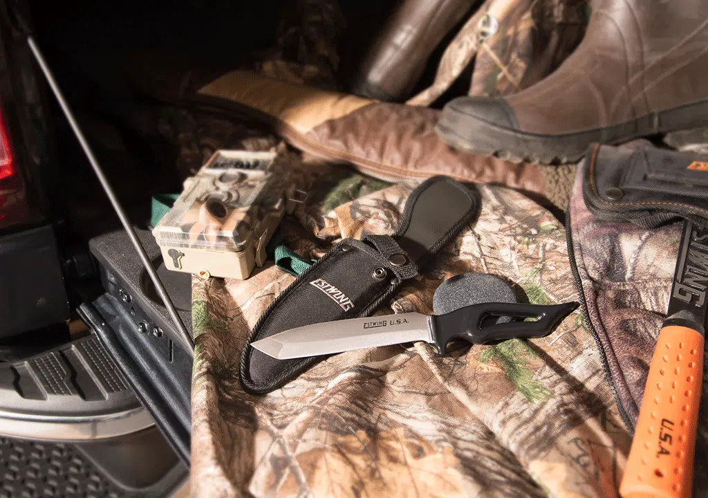 Hunting knife and axe on tailgate of truck bed