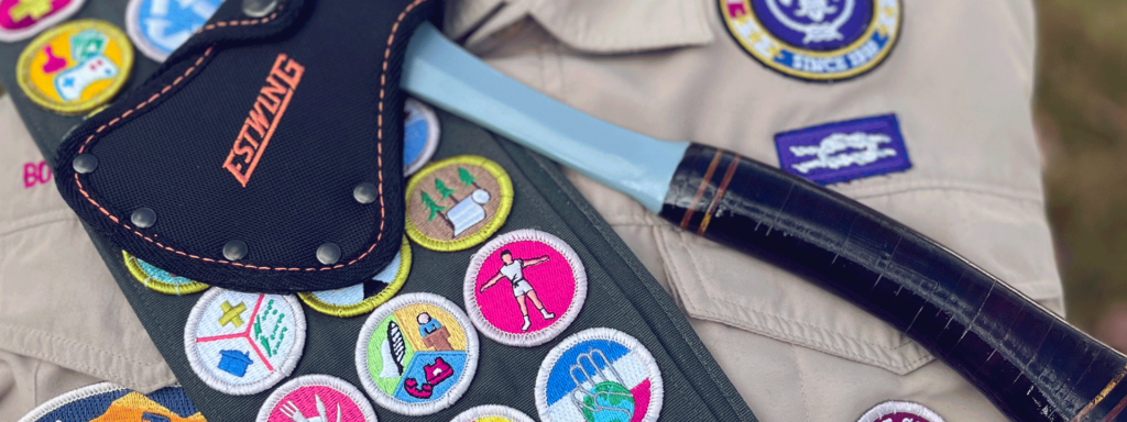 Estwing Sportsman's Axe laying on top of Eagle scout shirt and sash of merit badges
